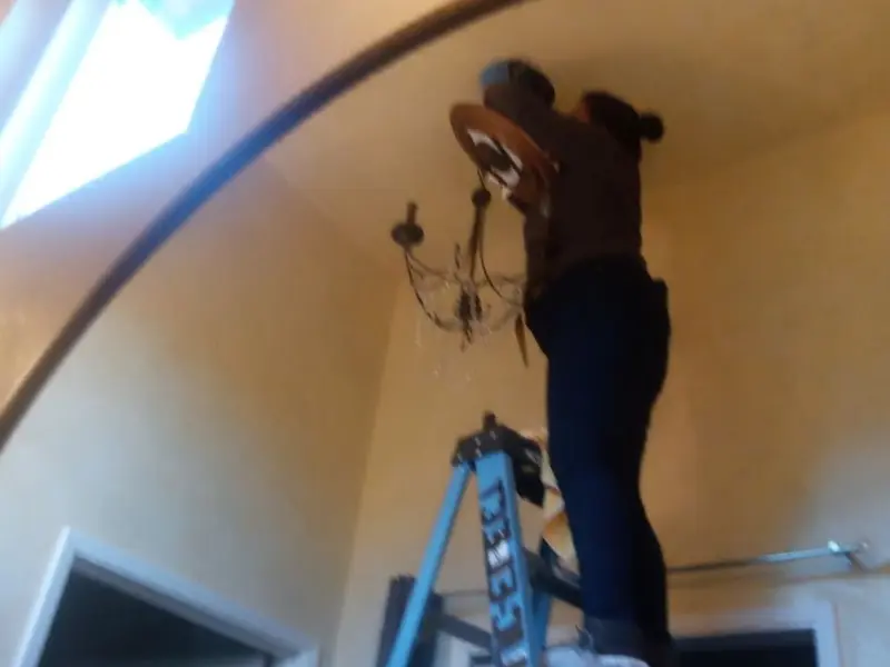 Electrician installing a chandelier in a Oglesby residence